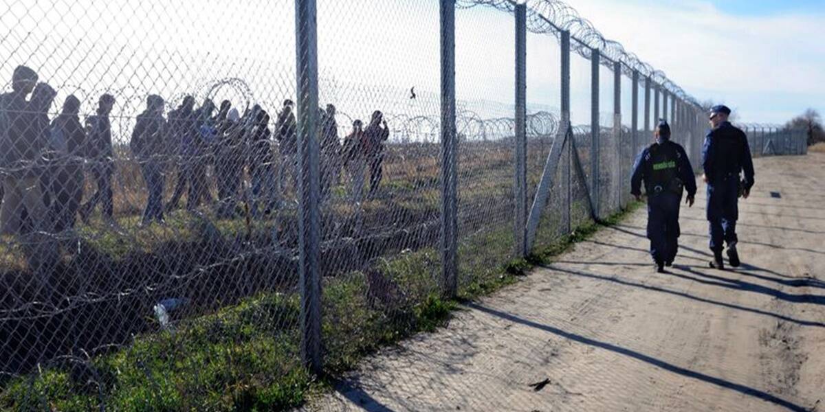 Magyar rendőrök figyelik a vajdasági oldalon tartózkodó migránsokat a magyar–szerb határon felállított ideiglenes határzárnál, Mórahalom térségében 2016. február 22-én (Fotó: MTI/Kelemen Zoltán Gergely)